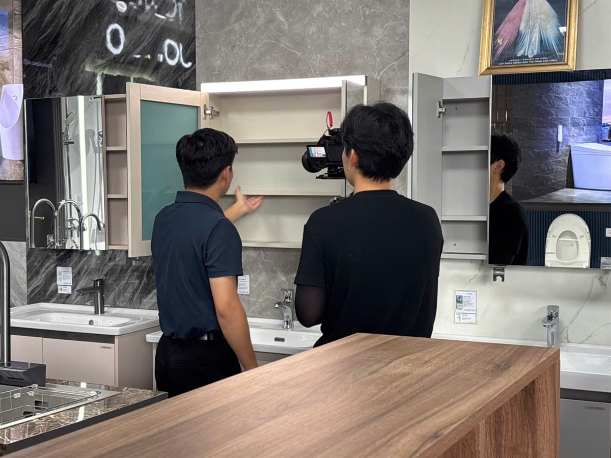 Filming the bathroom cabinet display at a JOMOO showroom.