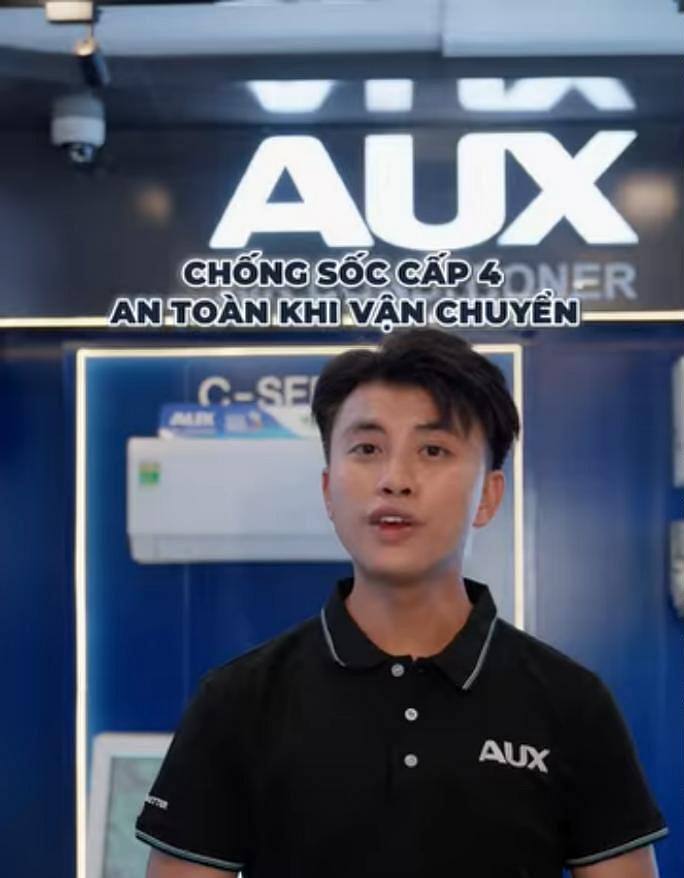A frame from an AUX short video: the presenter introducing shock protection in transit (Vietnamese on-screen text).