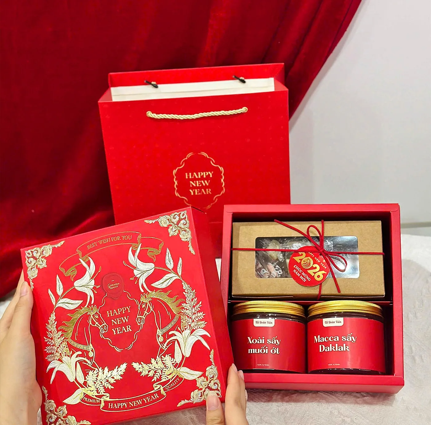 Red Tet gift box with two jars of nuts and dried fruit and a Happy New Year paper bag