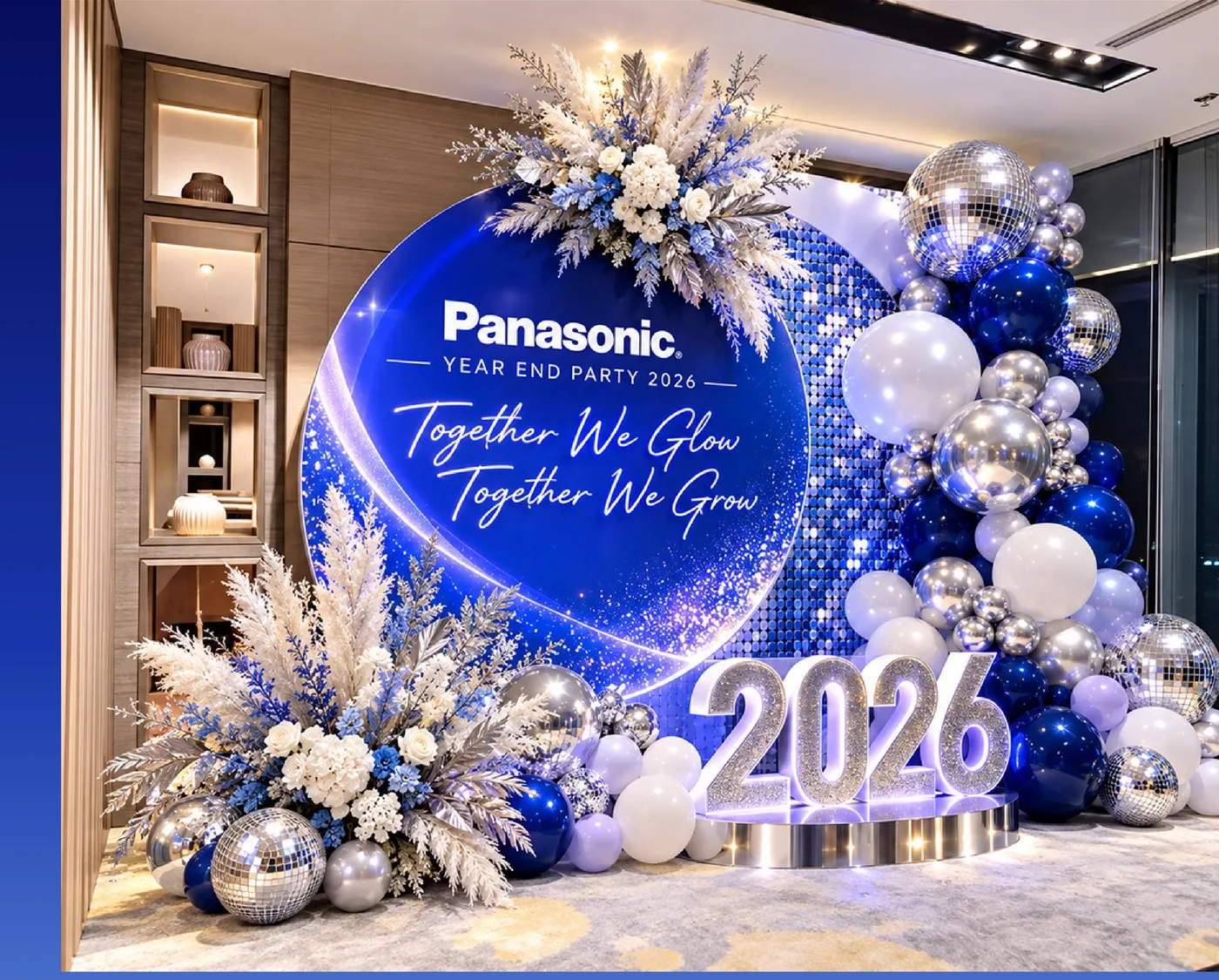 Round backdrop with pampas grass, silver balloons and illuminated year numbers for a Year End Party check-in zone