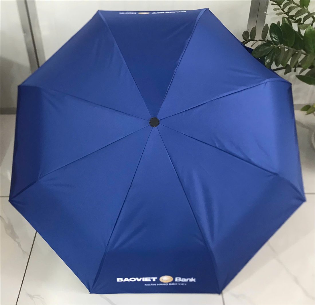 Open blue BAOVIET Bank folding umbrella with the logo printed on the canopy