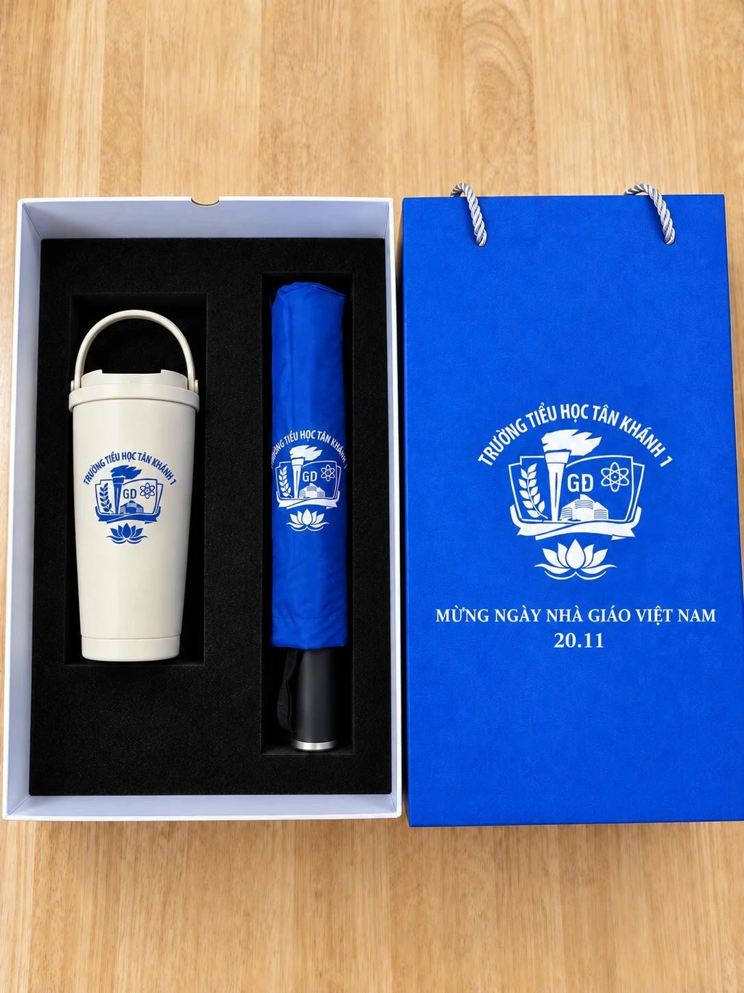 Teachers' Day set for Tan Khanh 1 Primary School with a tumbler and folding umbrella printed with the school logo and a gift bag