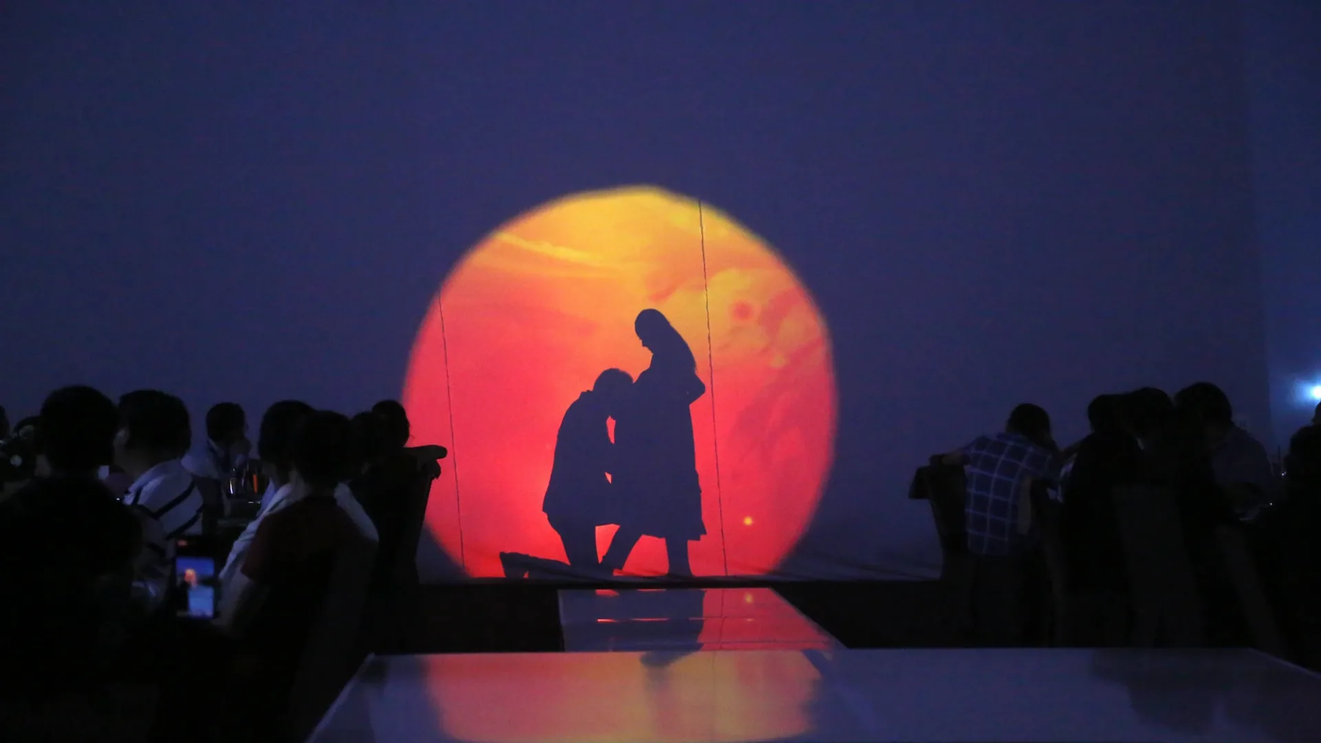 Shadow dance performance against red-orange light at the Panasonic dealer conference